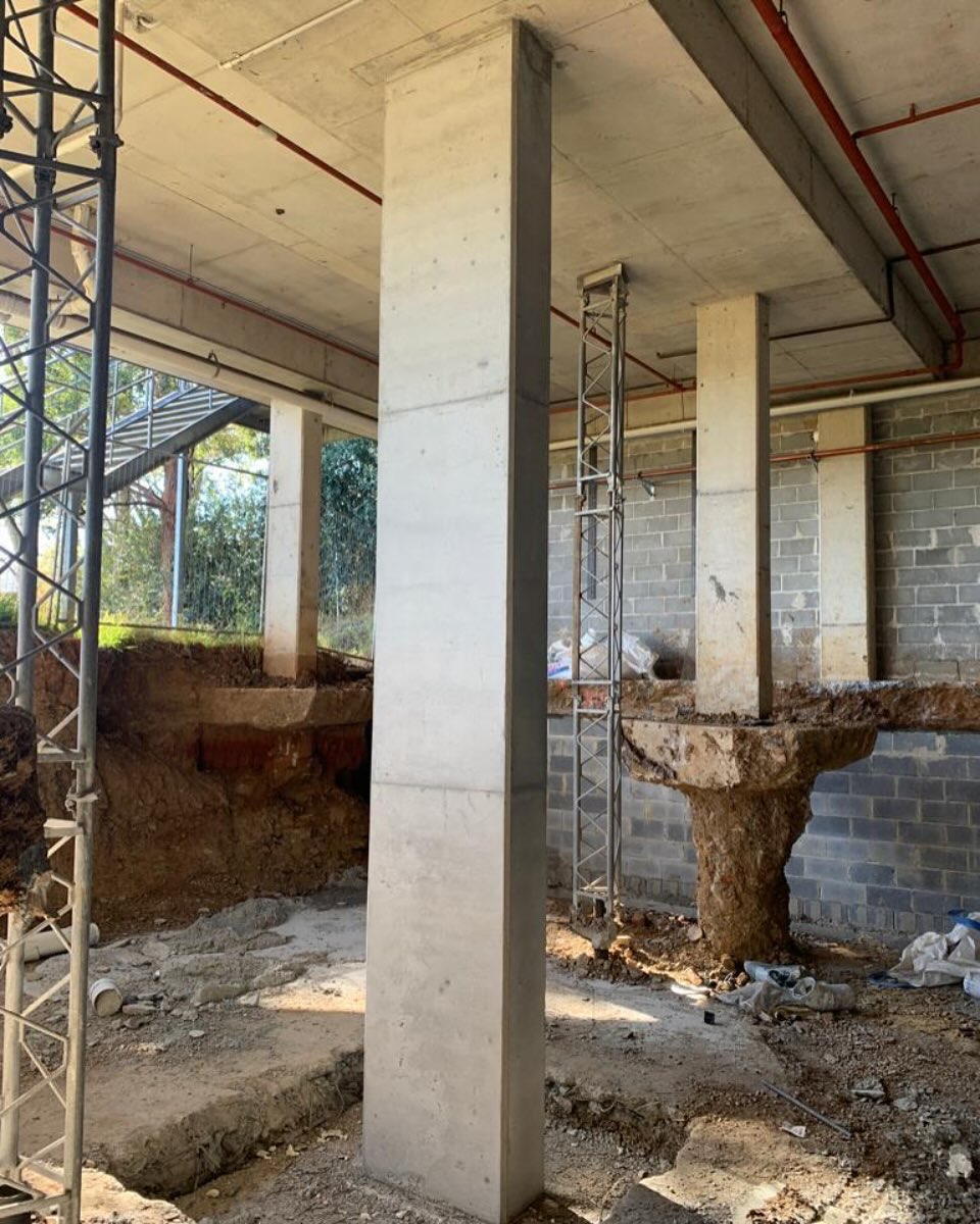 Completed concrete columns in a lower-level construction area